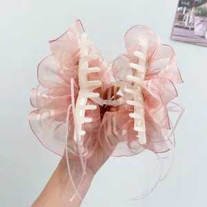 Detail shot of the elegant pink organza ribbon hair claw clip with striped texture.
