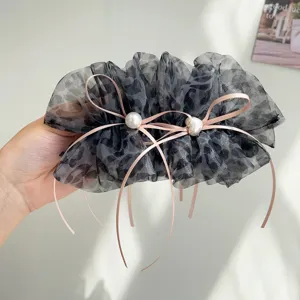 Vue détaillée de la pince à cheveux en tulle léopard avec rubans roses et perles