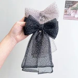 Vista detallada de elegantes pinzas para el cabello con lazo y estampado de leopardo.