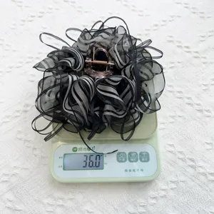 Close-up detail of a striped gauze ribbon hair claw clip weighing exactly 36.0 grams