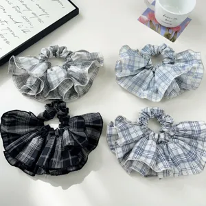 Close-up of four plaid ruffled hair scrunchies in various colors for daily styling.