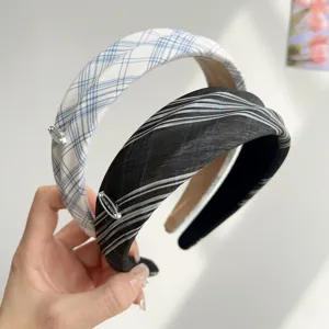 Λεπτομερής προβολή φαρδιών καρό στέκες σε preppy στυλ με μεταλλική ετικέτα Hand Made.