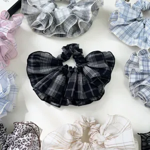 Top-down view of various plaid and leopard print ruffled oversized scrunchies