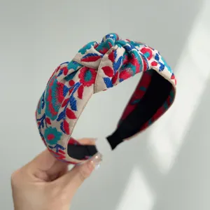 Vista detallada de una diadema anudada bohemia con bordado floral étnico vibrante