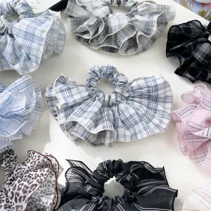 Detailed view of various plaid and leopard print ruffled hair scrunchies set