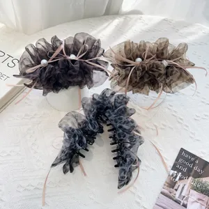 Vue détaillée de pinces à cheveux léopard avec rubans roses et perles
