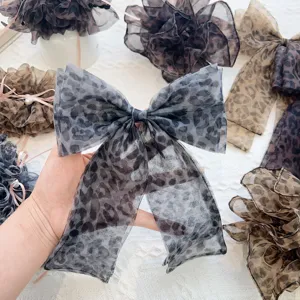 Détail rapproché du tissu en maille léopard et du design romantique du nœud de pince