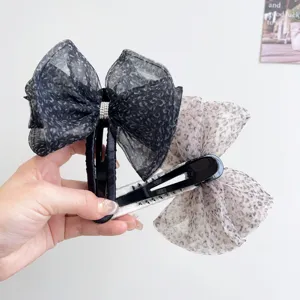 Detalle de pinzas para el cabello vintage con lazo de malla de leopardo y brillantes