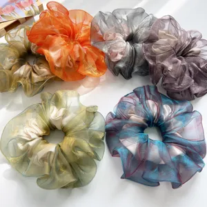 Detailansicht verschiedener farbenfroher Organza-Haargummis mit schimmernder Textur.