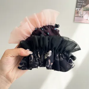 Vue détaillée de pinces à cheveux élégantes avec dentelle à pois et motifs paisley.