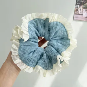Detalle de un coletero a cuadros azules con bordes de volantes en tela suave