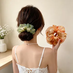 Detailansicht großer schillernder Organza-Haargummi in Grün und Orange