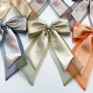 Multi-colored shimmering organza ribbon bow hair clips showing elegant iridescent texture.