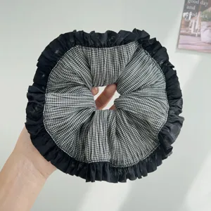 Primer plano de un scrunchie de cuadros blanco y negro con elegantes bordes plisados