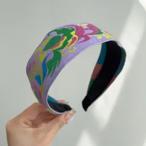 Close-up of purple bohemian embroidered headband with vintage folk style patterns