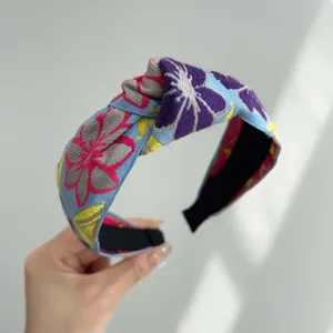 Detalle de diadema bohemia con nudo y bordados florales de colores vivos