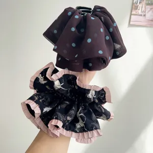 Détail rapproché de l'élégant motif à pois en résille et du tissu plissé sur ces pinces à cheveux.