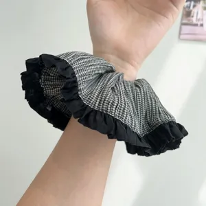 Detalle de coletero de cuadros vichy blanco y negro con elegantes bordes de encaje rizados
