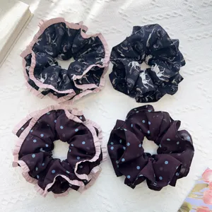 Vue détaillée de quatre chouchous en tulle à pois et motifs cachemire avec volants roses.