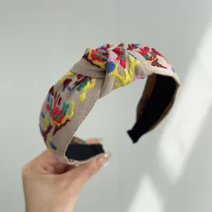Primer plano de diadema anudada bohemia con bordado étnico de varios colores