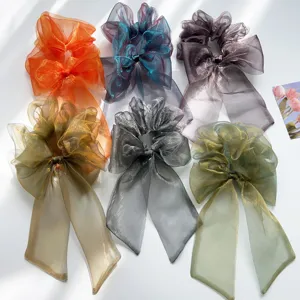 Sechs farbenfrohe schillernde Organza-Haargummis mit Schleife auf weißem Boden