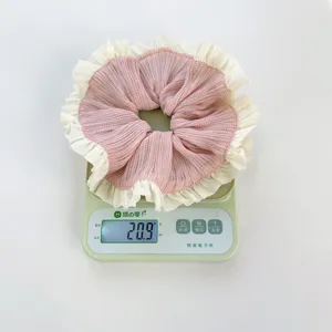Coletero de tela a cuadros rosas con volantes blancos en una báscula electrónica