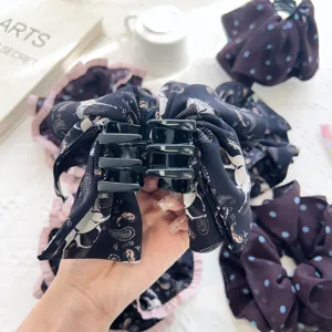Détail de la pince à cheveux noire avec tissu à imprimé Pégase et chouchous à pois