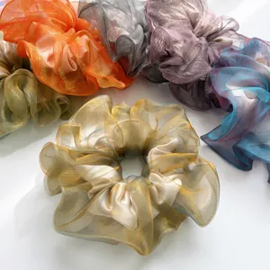 Detailaufnahme von schimmernden, irisierenden Haargummis aus Organza in verschiedenen Farben