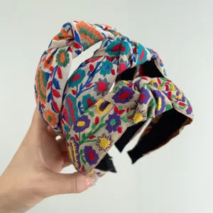 Primer plano de tres diademas de nudos bohemias con motivos florales étnicos vivos