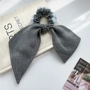 Detailansicht eines eleganten grauen Haargummis mit hellblauen Faltenkanten-Details