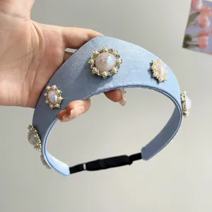 Nahaufnahme eines hellblauen Satin-Haarreifs mit eleganten Perlenblumen-Verzierungen.