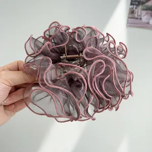 Detailed view of the layered ruffled mesh texture on a rose gold hair claw clip