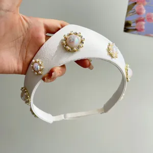 Nahaufnahme eines eleganten weißen Satin-Haarreifens mit Vintage-Perlen und Strass.