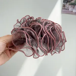 Close-up view of an elegant dark mauve mesh ruffled hair claw clip with pink piping details.