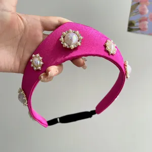 Detailansicht eines rosa Satin-Haarbandes im Vintage-Stil mit Perlen und Kristallen