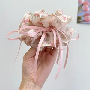 Detailed view of an elegant floral print hair scrunchie with long pink ribbon streamers