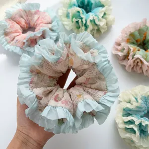 Close-up of floral print mesh scrunchy with light blue frilled edges details