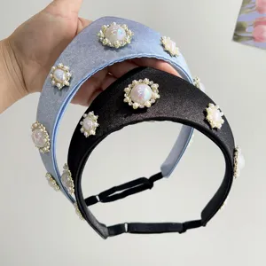 Nahaufnahme von Retro-Stirnbändern mit eleganten Perlen- und Kristallblumen auf Satinstoff