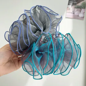 Close-up of iridescent organza bow hair claws in grey and blue shades