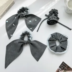 Detailansicht grauer Scrunchies mit Rüschen und Haargummis mit Schleife im Set