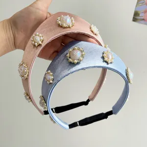 Detailansicht von zwei Vintage-Haarreifen mit Perlen und Kristallen auf Satinstoff.
