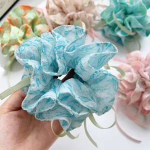 Close-up of elegant floral print hair scrunchie with ribbons for bun hairstyles