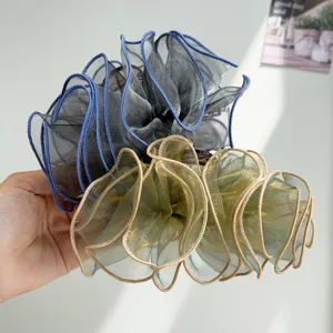 Close-up of large ruffled mesh hair claw clips with elegant wavy texture.