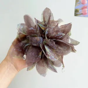 Vista dettagliata di un grande elastico a fiore in tessuto iridescente con cristalli