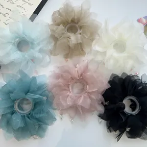 Dettaglio di vari elastici per capelli in tessuto velato pastello con accenti di perline di cristallo