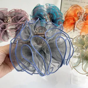 Close-up of elegant mesh fabric flower hair claw with wavy edges and metal clip