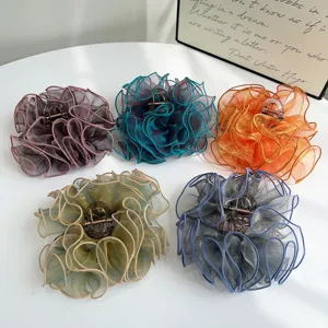 Detailed display of five large ruffled organza hair claw clips in assorted colors.