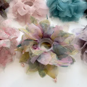 Vista dettagliata di un elastico per capelli in organza a fiori con ciondolo di cristallo