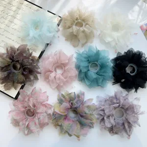 Dettaglio di vari elastici scrunchies in mesh a fiori e tinta unita, accessori capelli