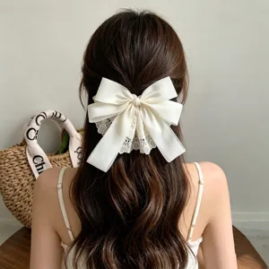 Close-up detail of oversized cream white double-layered lace bow hair clip styling